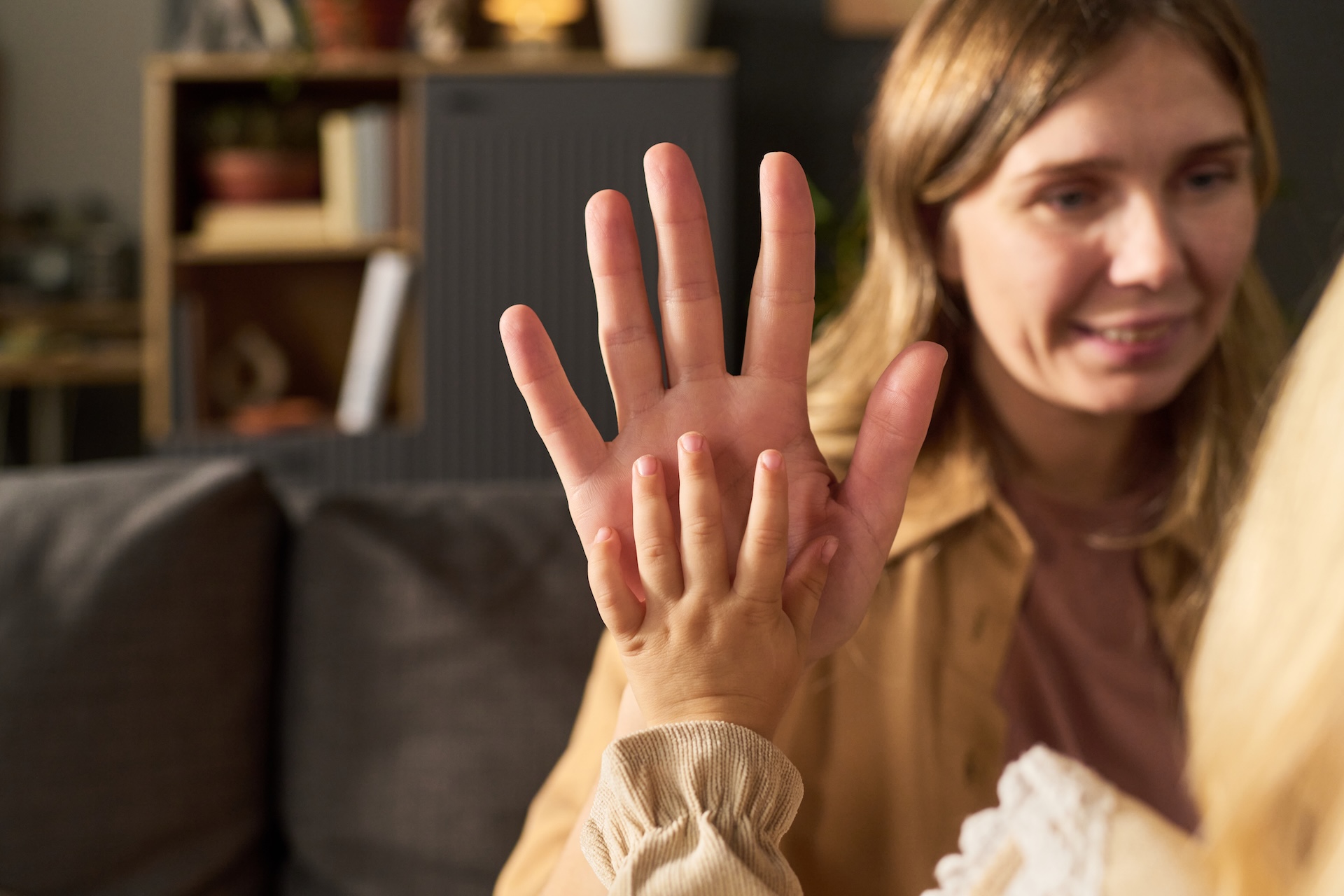 woman-smiling-while-touching-hand-with-young-child-2025-12-07-17-19-01-utc